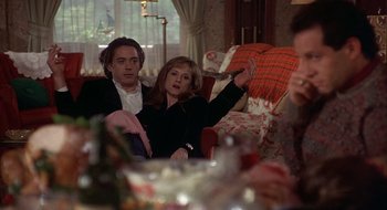 Movie still from “Home for the Holidays” (1995), directed by Jodie Foster – A man and a woman sitting on a red couch; Medium shot, Over the shoulder angle