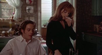 Movie still from “Home for the Holidays” (1995), directed by Jodie Foster – A man and a woman are standing in front of a phone; Medium shot, High angle