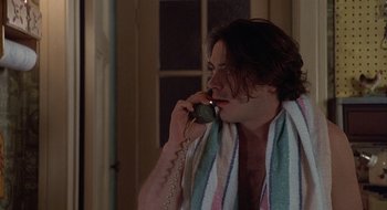 Movie still from “Home for the Holidays” (1995), directed by Jodie Foster – A man talking on a phone while wearing a towel around his neck; Close Up shot, High angle