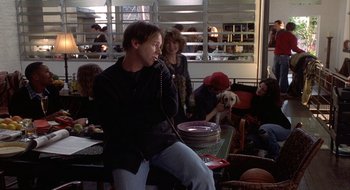 Movie still from “Home for the Holidays” (1995), directed by Jodie Foster – A man talking on a cell phone while sitting at a table; Medium shot, High angle