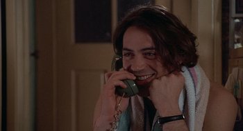 Movie still from “Home for the Holidays” (1995), directed by Jodie Foster – A man talking on a phone while wearing a towel around his neck; Close Up shot, Over the shoulder angle