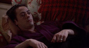 Movie still from “Home for the Holidays” (1995), directed by Jodie Foster – A man laying on a couch in a room; Close Up shot, High angle