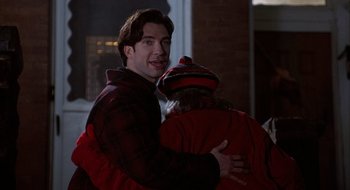 Movie still from “Home for the Holidays” (1995), directed by Jodie Foster – A man hugging a woman in a red jacket; Medium shot, Over the shoulder angle