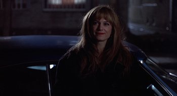 Movie still from “Home for the Holidays” (1995), directed by Jodie Foster – A woman with long red hair sitting in a dark room; Close Up shot, Over the shoulder angle