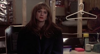 Movie still from “Home for the Holidays” (1995), directed by Jodie Foster – A woman in a black jacket is sitting down; Medium shot, Over the shoulder angle
