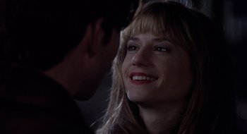 Movie still from “Home for the Holidays” (1995), directed by Jodie Foster – A person smiling with a man in the background; Close Up shot, Over the shoulder angle