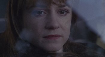 Movie still from “Home for the Holidays” (1995), directed by Jodie Foster – A woman's face in a dark room; Close Up shot, High angle