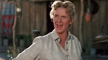 Movie still from “Hondo” (1953), directed by John Farrow – An older woman with blonde curly hair is smiling; Close Up shot, Low angle