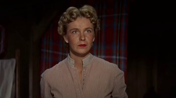 Movie still from “Hondo” (1953), directed by John Farrow – A woman in a striped shirt is looking at the camera; Close Up shot, Low angle