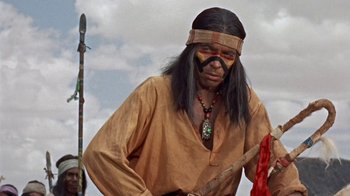 Movie still from “Hondo” (1953), directed by John Farrow – A man dressed as a native american holding a spear; Medium shot, Over the shoulder angle