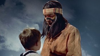 Movie still from “Hondo” (1953), directed by John Farrow – A man with long black hair and a beard talking to a young boy; Close Up shot, Over the shoulder angle