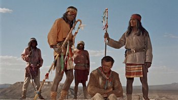 Movie still from “Hondo” (1953), directed by John Farrow – A group of native americans standing in the desert; Wide shot, Low angle