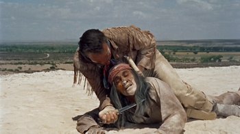 Movie still from “Hondo” (1953), directed by John Farrow – Two native americans are fighting in the sand; Medium shot, Overhead angle
