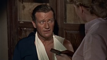 Movie still from “Hondo” (1953), directed by John Farrow – A man and a woman talking to each other; Medium shot, Over the shoulder angle