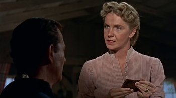 Movie still from “Hondo” (1953), directed by John Farrow – An older woman holding a cell phone while standing next to a younger man; Close Up shot, Over the shoulder angle