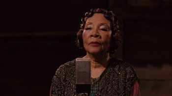 Movie still from “Honeydripper” (2007), directed by John Sayles – An older woman is singing into a microphone; Close Up shot, Low angle