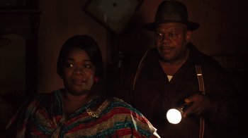 Movie still from “Honeydripper” (2007), directed by John Sayles – A man and a woman are standing in the dark with a flashlight; Medium shot, Over the shoulder angle