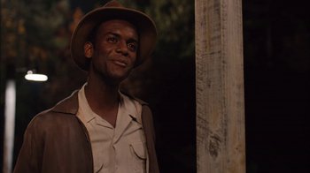 Movie still from “Honeydripper” (2007), directed by John Sayles – A man wearing a brown hat and a brown jacket; Close Up shot, Over the shoulder angle