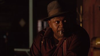 Movie still from “Honeydripper” (2007), directed by John Sayles – A man in a hat and a brown jacket is smoking a cigarette; Close Up shot, Low angle