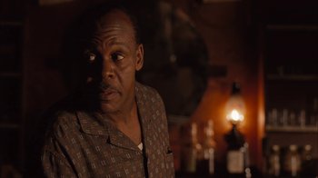 Movie still from “Honeydripper” (2007), directed by John Sayles – An older man sitting in front of an oil lamp in a dark room; Close Up shot, Over the shoulder angle