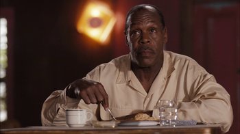 Movie still from “Honeydripper” (2007), directed by John Sayles – A man sitting at a table with a plate of food; Close Up shot, Low angle
