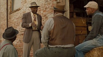 Movie still from “Honeydripper” (2007), directed by John Sayles – Two men in suits and hats talking to each other; Medium shot, Over the shoulder angle