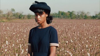 Movie still from “Honeydripper” (2007), directed by John Sayles – A woman in a black dress standing in front of a field of cotton; Medium shot, Over the shoulder angle