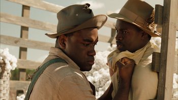 Movie still from “Honeydripper” (2007), directed by John Sayles – A couple of men standing next to each other; Close Up shot, Over the shoulder angle
