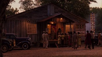 Movie still from “Honeydripper” (2007), directed by John Sayles – A group of people standing in front of a building; Extreme Wide shot, High angle
