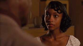 Movie still from “Honeydripper” (2007), directed by John Sayles – A young woman with dark curly hair wearing a white dress; Close Up shot, Over the shoulder angle