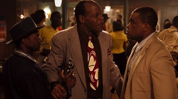 Movie still from “Honeydripper” (2007), directed by John Sayles – A man wearing a suit and tie talking to two other men; Medium shot, Over the shoulder angle