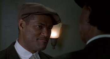 Movie still from “Hoodlum” (1997), directed by Bill Duke – A person wearing a hat and a suit; Close Up shot, Low angle