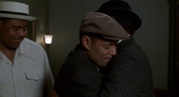 Movie still from “Hoodlum” (1997), directed by Bill Duke – A man wearing a hat is hugging another man; Close Up shot, High angle