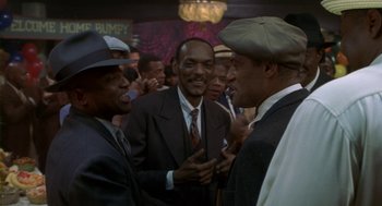 Movie still from “Hoodlum” (1997), directed by Bill Duke – A group of men standing around talking to each other; Medium shot, Low angle