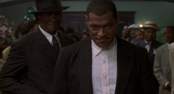 Movie still from “Hoodlum” (1997), directed by Bill Duke – A man wearing a suit and tie standing next to another man; Close Up shot, Low angle