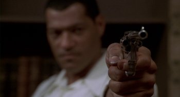 Movie still from “Hoodlum” (1997), directed by Bill Duke – A person holding a gun in his hand; Extreme Close Up shot, Low angle