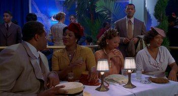 Movie still from “Hoodlum” (1997), directed by Bill Duke – A group of people sitting around a table; Medium shot, Over the shoulder angle
