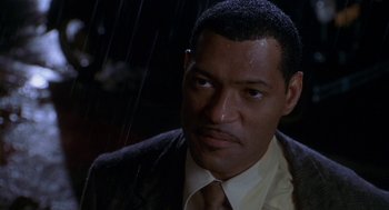 Movie still from “Hoodlum” (1997), directed by Bill Duke – A man in a suit and tie standing in the rain; Close Up shot, High angle