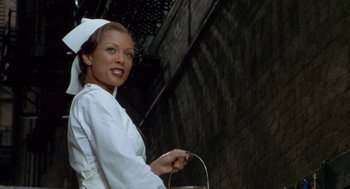 Movie still from “Hoodlum” (1997), directed by Bill Duke – A woman dressed as a nurse is holding a bucket; Medium shot, Low angle
