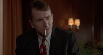 Movie still from “Hoodlum” (1997), directed by Bill Duke – A man wearing a suit and tie smoking a cigarette; Close Up shot, Over the shoulder angle