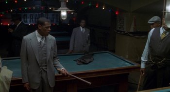 Movie still from “Hoodlum” (1997), directed by Bill Duke – Two men in suits and ties playing pool in a room; Wide shot, Over the shoulder angle