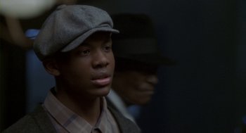 Movie still from “Hoodlum” (1997), directed by Bill Duke – A young man wearing a hat and a plaid shirt; Close Up shot, High angle