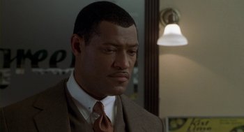 Movie still from “Hoodlum” (1997), directed by Bill Duke – A man in a brown suit and a brown tie; Close Up shot, Over the shoulder angle