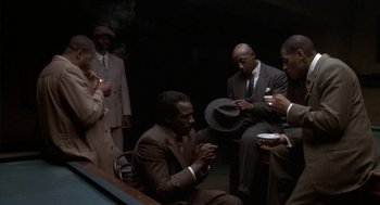 Movie still from “Hoodlum” (1997), directed by Bill Duke – A group of men in suits and ties sitting around a table; Medium shot, High angle
