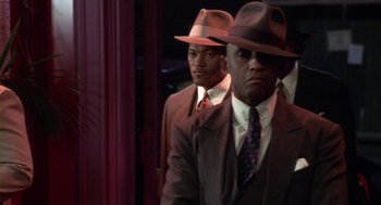 Movie still from “Hoodlum” (1997), directed by Bill Duke – A couple of men wearing suits and hats; Medium shot, Over the shoulder angle