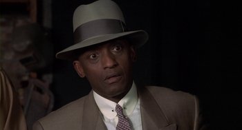 Movie still from “Hoodlum” (1997), directed by Bill Duke – A man wearing a suit and a hat; Close Up shot, High angle