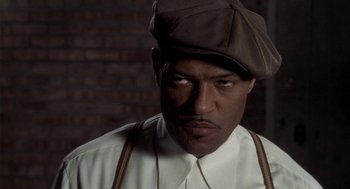 Movie still from “Hoodlum” (1997), directed by Bill Duke – A man wearing a brown hat and a white shirt; Close Up shot, High angle