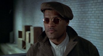 Movie still from “Hoodlum” (1997), directed by Bill Duke – A person wearing sunglasses and a hat; Close Up shot, High angle