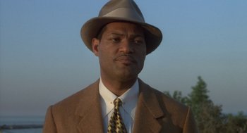 Movie still from “Hoodlum” (1997), directed by Bill Duke – A man wearing a suit and a hat; Close Up shot, Low angle
