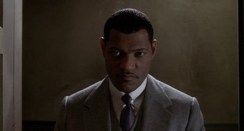 Movie still from “Hoodlum” (1997), directed by Bill Duke – A man wearing a suit and tie with a mustache; Close Up shot, Low angle